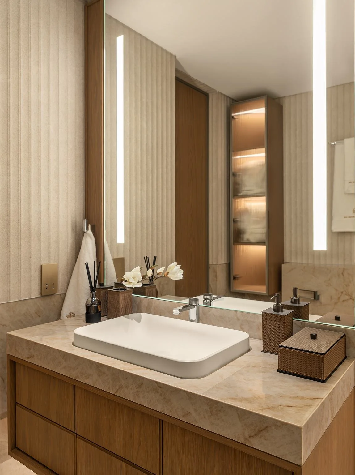 En-suite bathroom vanity with backlit mirror and quartzite counter